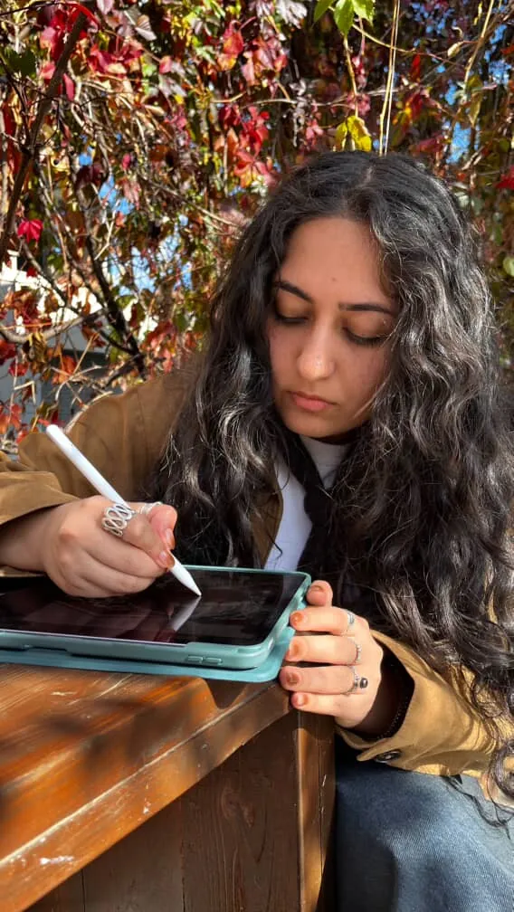 The artist drawing the print on a tablet outdoors